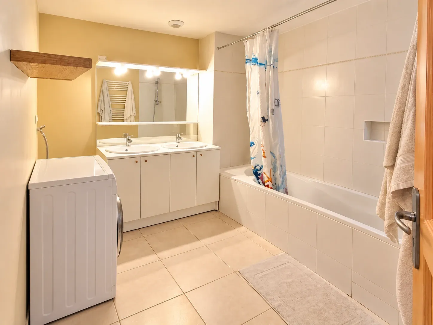 Salle de bain avec double vasque et baignoire